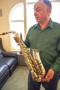 Tim Price talks about one of his saxophones. Dean Hare/Daily News